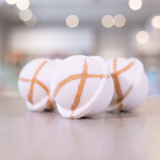 Three white bath bombs lined up on counter with gold bronze design